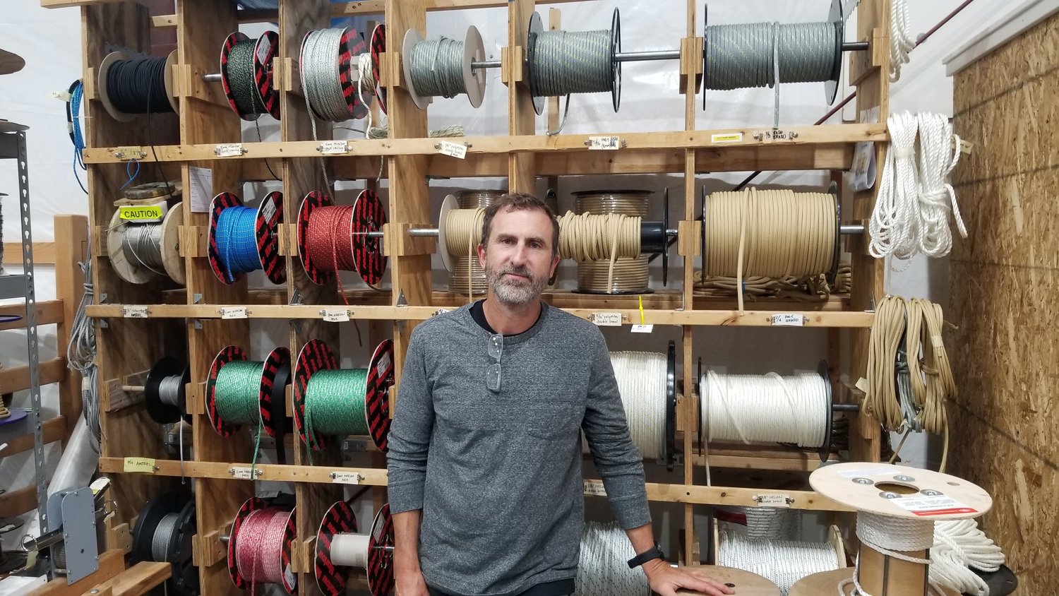 Josh Colvin, owner of Duckworks, poses for a photo in front of a wide variety of rope he offers to customers seeking certain specifications for their marine applications.